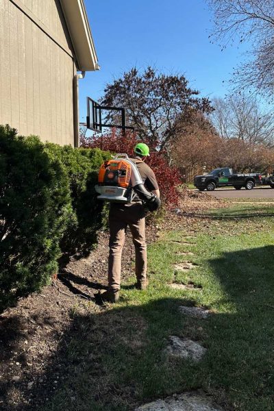 lawn technician cleaning up leaves