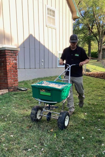 lawn technician seeding lawn in the fall